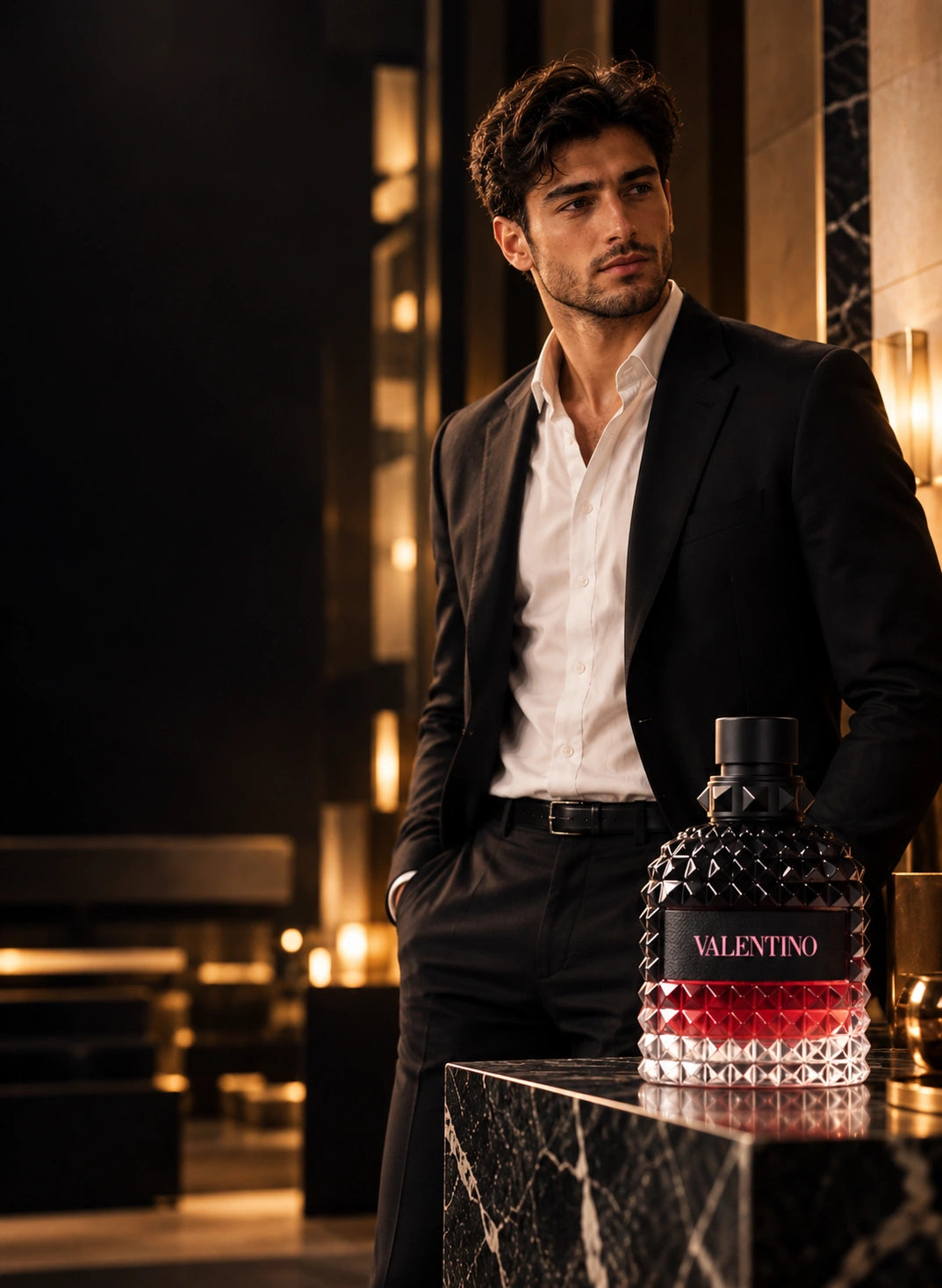 Male model in a tailored black suit with Valentino perfume on dark marble